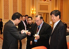中聯辦台務部丁副部長(左一)與台灣僑聯總會簡漢生理事長交換名片